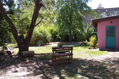 a bench sitting in a yard next to a tree at Casa del bosque in Benavídez