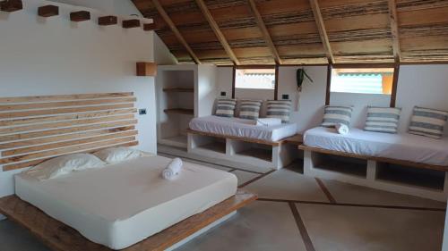 a room with four beds in a room at La Posada del Gecko in Capurganá