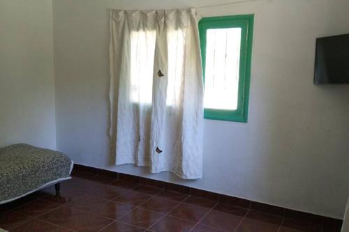um quarto com uma janela, uma cama e uma viseira em Casa del bosque em Benavídez