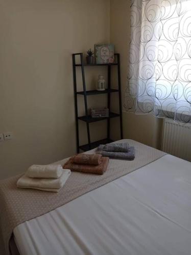 a bedroom with a bed with two towels on it at Διαμέρισμα με θέα σε πάρκο! in Serres