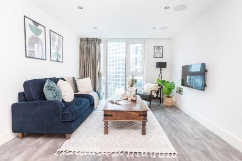 a living room with a blue couch and a table at Tower Bridge & Liverpool Street - CityApartmentStay in London