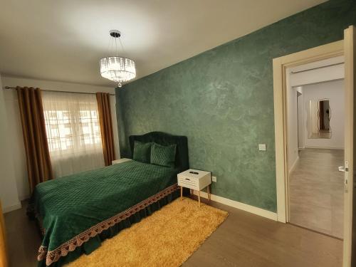 a bedroom with a bed with a green wall at Premium Apartment with Free Parking and Shop near Airport in Iaşi