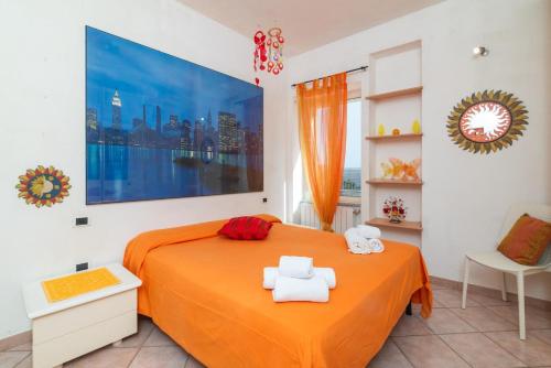 a bedroom with an orange bed with two towels at LA TERRAZZA SULL'INSENATURA in Santa Teresa Gallura