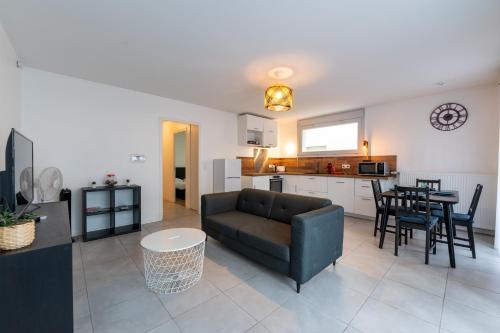 un salon avec un canapé et une table et une cuisine dans l'établissement T3 Grenoble, tout confort, balcon, wifi, à Grenoble