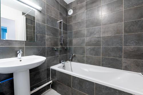 une salle de bain avec un lavabo et une baignoire dans l'établissement T3 Grenoble, tout confort, balcon, wifi, à Grenoble