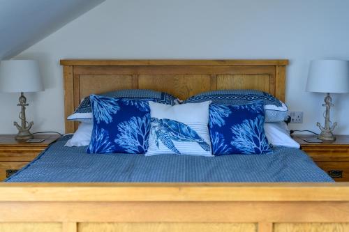 a bed with blue and white pillows on it at Coast Guest House in Whitby