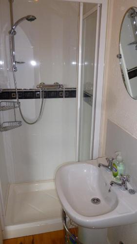 a white bathroom with a sink and a shower at Corcoran's Lodge in Ferns