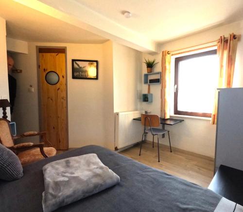 a bedroom with a bed and a desk and a window at Aux deux amis in Stavelot