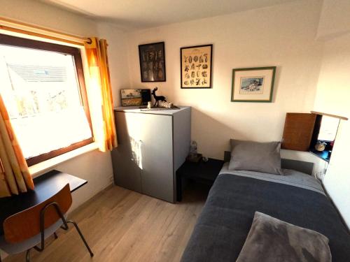 a small bedroom with a bed and a window at Aux deux amis in Stavelot