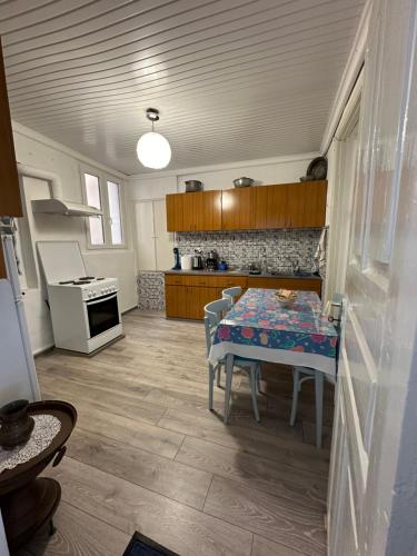 uma cozinha com uma mesa e uma cozinha com um fogão em Old Town Traditional Residence em Kavala