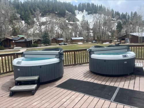 two trash cans on a deck with a hot tub at High Creek Lodge and Cabins in Pagosa Springs