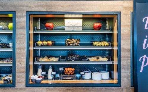 a bakery display case with food on shelves at MOXY Vienna Airport in Schwechat