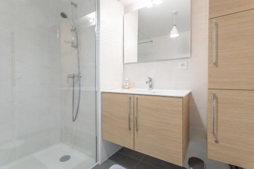 a bathroom with a shower and a sink and a mirror at L’hermine avec parking 500m plage in Concarneau