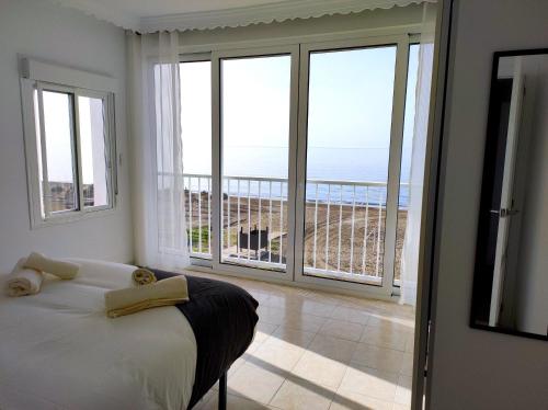 um quarto com uma cama e vista para o oceano em La Parada Beach em Torre de Benagalbón
