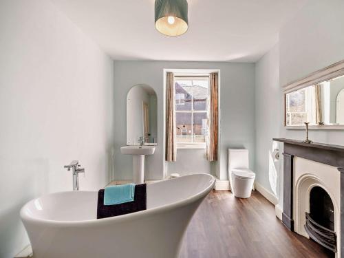 a white bath tub in a bathroom with a fireplace at 6 Bed in Dolgellau 91711 in Dolgellau