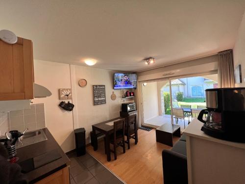 une cuisine et un salon avec une table et des chaises dans l'établissement Appt hyper-centre Loudenvielle 4 Personnes Jardin et Terrasse, à Loudenvielle
