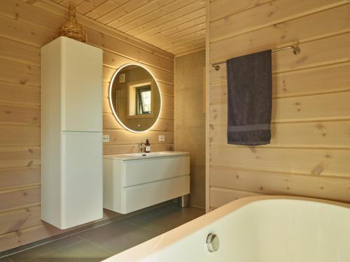 un bagno con vasca, lavandino e specchio di Furuheim Lodge, 4 seizoenen vakantiehuis met fantastisch uitzicht a Vrådal