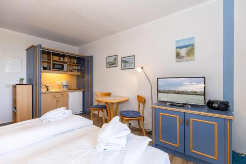 a bedroom with two beds and a flat screen tv at Yachthafenresidenz-Wohnung-5102-806 in Kühlungsborn