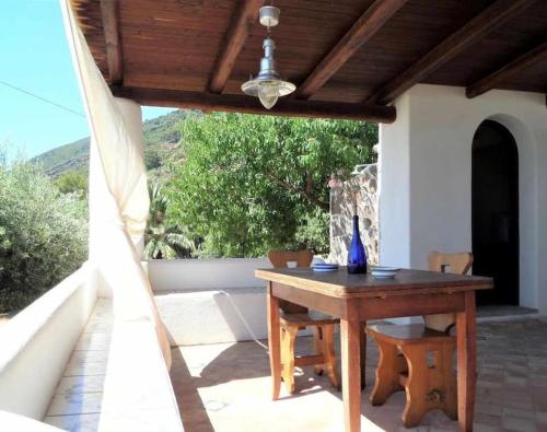 a wooden table and chairs on a patio at Casa Cavalluccio Marino - terrazza vista mare in Santa Marina Salina