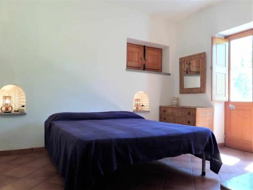 a bedroom with a blue bed and a window at Casa Cavalluccio Marino - terrazza vista mare in Santa Marina Salina