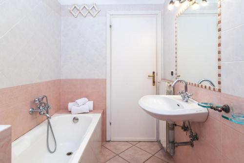 a bathroom with a tub and a sink and a bath tub at LA TERRAZZA SULL'INSENATURA in Santa Teresa Gallura