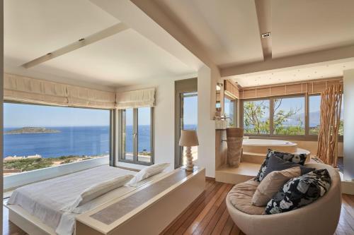 a bedroom with a large bed and a large window at Elounda White Pearl Villa in Agios Nikolaos