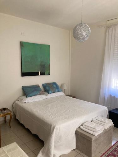a bedroom with a large bed with a green painting on the wall at Villa Delle Rose in Bra