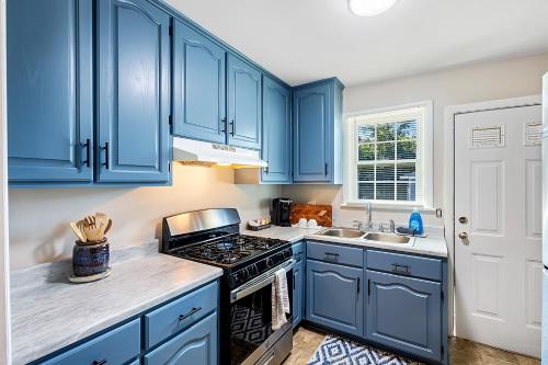 a kitchen with blue cabinets and a stove top oven at Firefly Hideaway near Riverwalk in North Augusta