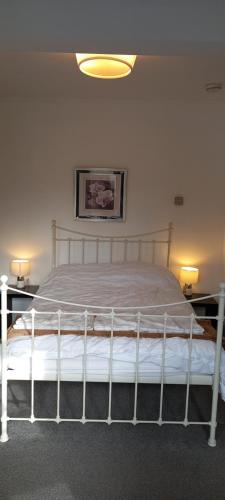 a white bed in a room with two lamps at Large, Private Ensuite, Bay Window Room. in Sheffield