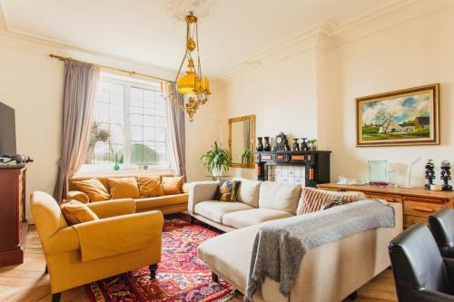 a living room with two couches and a rug at Beautiful mansion with swimming pool and jacuzzi in Bilzen