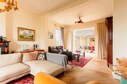 een woonkamer met een bank en een tafel bij Beautiful mansion with swimming pool in Bilzen