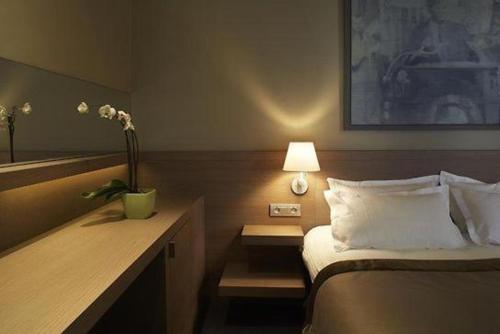 Habitación de hotel con cama y escritorio con lámpara. en Gravenhof en Beersel