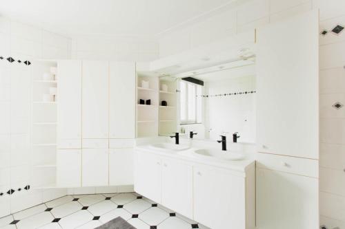 a white bathroom with two sinks and a mirror at Beautiful mansion with swimming pool and jacuzzi in Bilzen