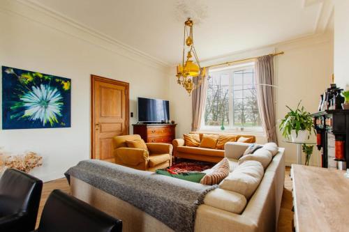 a living room with a couch and a table at Beautiful mansion with swimming pool and jacuzzi in Bilzen