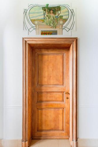 a wooden door in a room with a painting on the wall at Beautiful mansion with swimming pool and jacuzzi in Bilzen