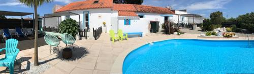 a villa with a swimming pool in front of a house at Casa o Futuro in Alcobaça