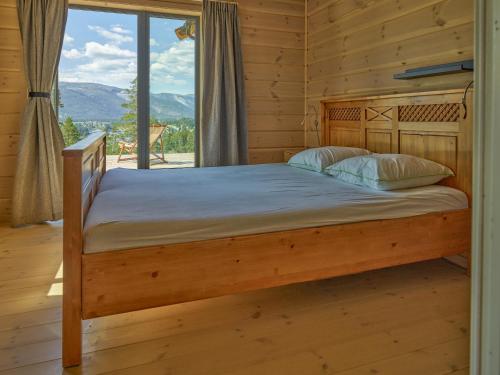 a bedroom with a bed in a log cabin at Furuheim Lodge, 4 seizoenen vakantiehuis met fantastisch uitzicht in Vradal