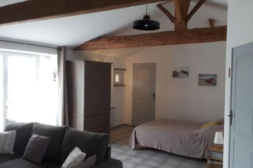 un salon avec un canapé et un lit dans l'établissement Appartement de vacances entre mer et campagne, à Le Port-des-Barques