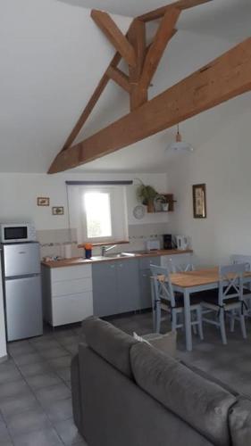 Il dispose d'une cuisine et d'un salon avec un canapé et une table. dans l'établissement Appartement de vacances entre mer et campagne, à Le Port-des-Barques