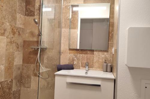 une salle de bain avec un lavabo et une douche avec un miroir dans l'établissement LET'S - Le Jules -Part dieu Wifi, à Villeurbanne