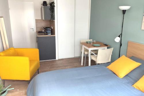 une chambre avec un lit, une table et une chaise dans l'établissement LET'S - Le Jules -Part dieu Wifi, à Villeurbanne