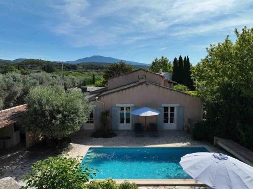 une maison avec une piscine et un parasol dans l'établissement The Olive Garden - Charming Villa for 10 with pool and fast Wifi, à Caromb