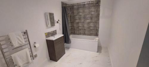 a bathroom with a tub and a sink and a shower at Hatfield Lodge in Lowestoft