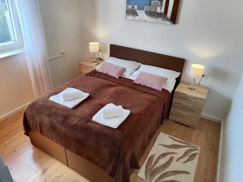 a bedroom with a large bed with two towels on it at APARTMENT MARINA VIEW in Zadar
