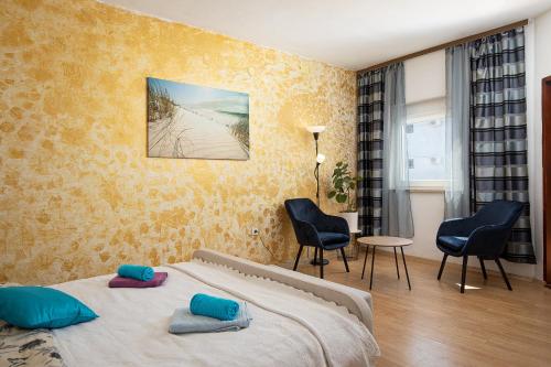 a bedroom with a bed with blue pillows on it at Apartment Majer in Medulin