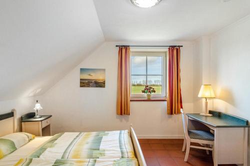a bedroom with a bed and a desk and a window at Ostfriesland in Krummhörn
