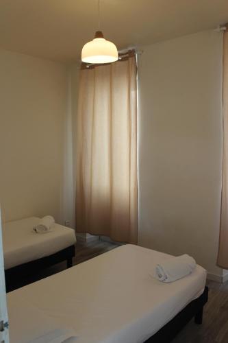Zimmer mit 2 Betten und einer Lampe in der Unterkunft Bienvenus à Thèse - Appartement Orange in Marseille