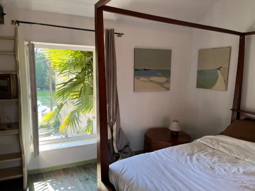 ein Schlafzimmer mit einem Bett und einem großen Fenster in der Unterkunft la Belle Seine in Samois-sur-Seine