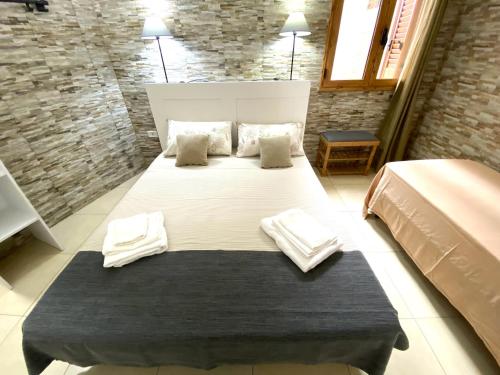 a bedroom with a large bed with towels on it at Villa GAUDÌ in Sant'Isidoro