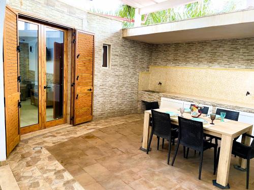 a patio with a table and chairs and a fireplace at Villa GAUDÌ in Sant'Isidoro
